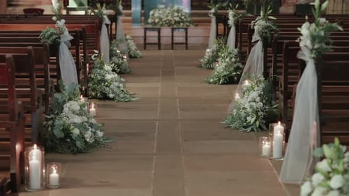 church aisle decorated with flowers and candles for wedding