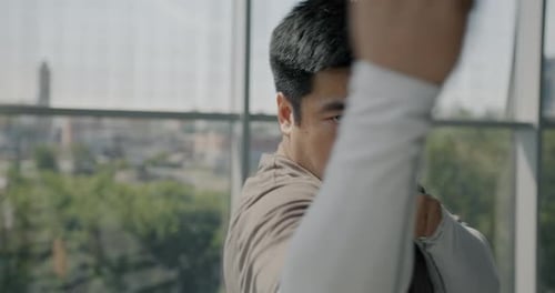 Portrait of Masculine Asian Sportsman Throwing Punches Training in Gym and Looking at Camera