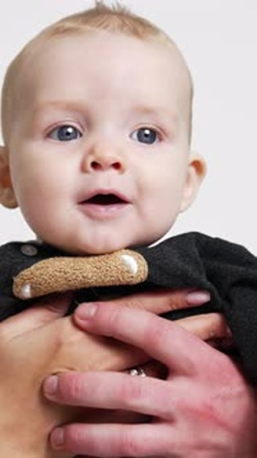 Loving Parents Kissing Baby in Studio