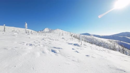 Erkunden Sie die atemberaubende schneebedeckte Landschaft der Bergkette, aufgenommen von oben in atemberaubender Weise