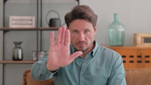 Stop Gesture by Middle Aged Man Sitting at Home