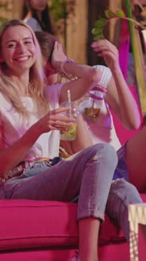 Two Young Women Laughing Together At Outdoor Party