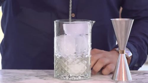 barman mixing a cocktails with ice and alcohol outside bar, slow motion