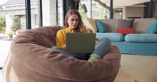 Woman Using Laptop Relaxing in Beanbag at Home