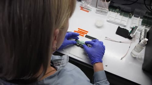 Woman in Blue Gloves Assembles Refrigerator Part at Table