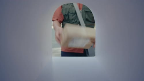 Postal Service Worker Delivering Parcel to Mailbox