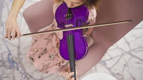 Woman plays a purple violin from above