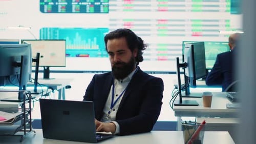 Thoughtful Man Working on Laptop in Modern Office