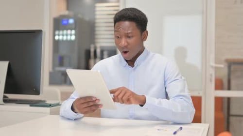African Businessman with Loss on Tablet in Office