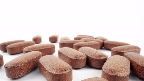 Close up of Brown Pills on White Surface