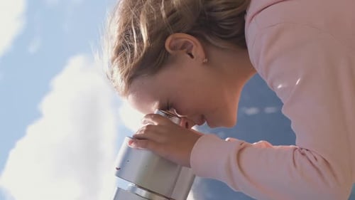 Child Viewing Mountain Scenery Through Telescope