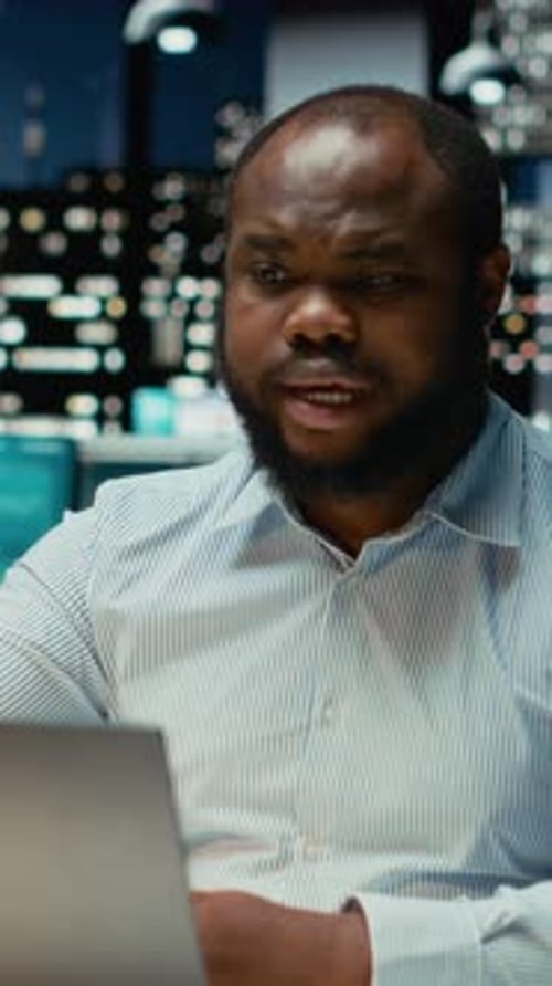 Vertical Video Black Businessman Engaging in Online Video Call From Dark Office