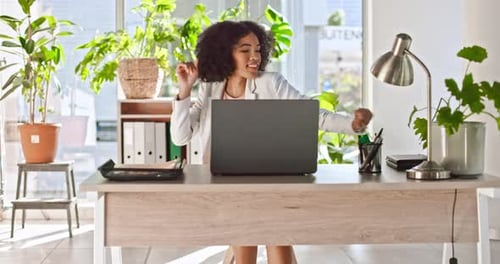 Woman Dances at Her Desk While Using Laptop