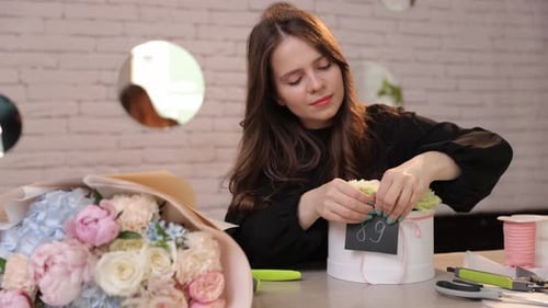 Florist Attaching Branding Tag to Luxury Flower Gift Box