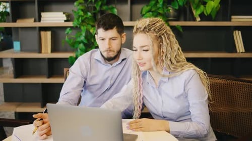 Two Skilled Professionals are Productively Engaged in a Collaborative Project While Working Together