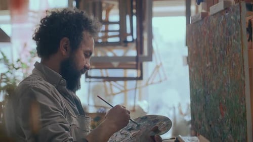 Talented Male Artist Painting Abstract Art on Canvas in Creative Studio