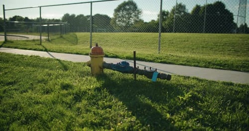 Fire Hydrant Safety Inspection Flow Testing. Water Dripping from Leaking Industrial Pipeline in Gras