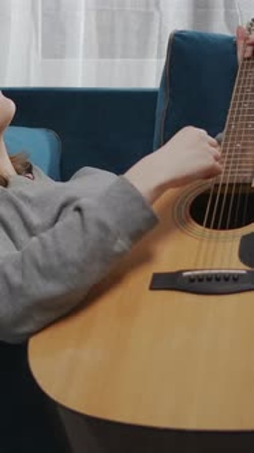 Woman Relaxing, Playing Acoustic Guitar on Couch