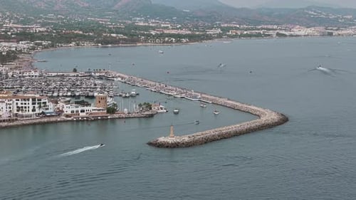 Aerial Coastal Harbor View with Boats and Clouds on a Tranquil Day