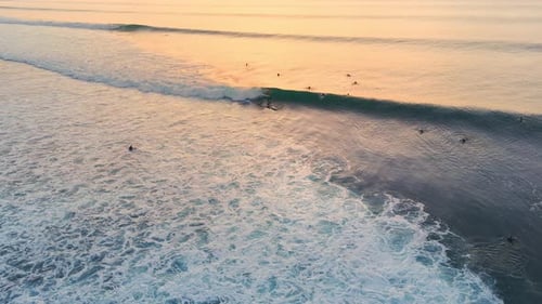 Ocean with Perfect Waves and Surfers with Evening Sunlight Drone View