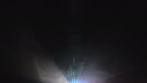 Faisceaux lumineux du projecteur se déplaçant dans l'obscurité
