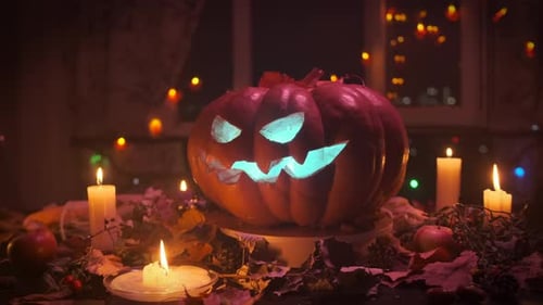 Illuminated Jack-o-Lantern with Candles and Autumn Leaves