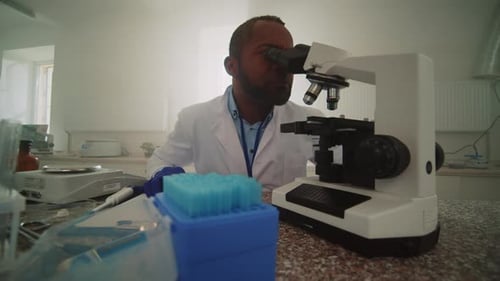 Scientist Using Microscope in Bright Laboratory Setting
