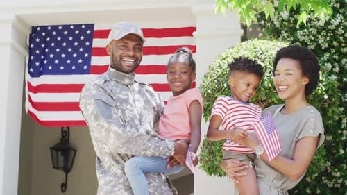 Happy Family Smiling Outside Home with American Flag