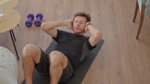 Man Doing Sit-Ups at Home on Exercise Mat