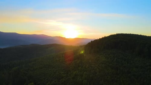 Aerial View of Bright Foggy Morning Over Dark Hills with Mountain Forest Trees at Autumn Sunrise