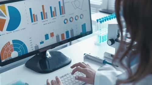 Scientist Analyzing Complex Data Visualizations and Laboratory Results on a Computer Monitor in a