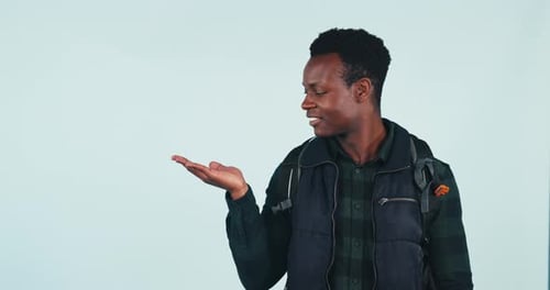 Male, student and pointing in studio on blue background in mockup of presentation for product