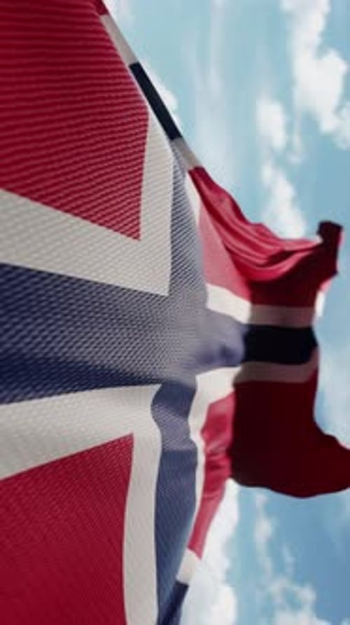 Waving Flag of Norway Against Blue Sky Background