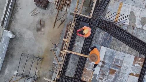 Luftbild: Beschäftigte Arbeiter, die bei einem neuen Projekt Betonstahl verbiegen und Fußböden vorbereiten