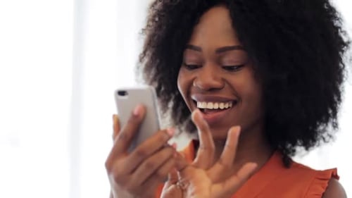 Smiling woman interacting with her mobile device indoors