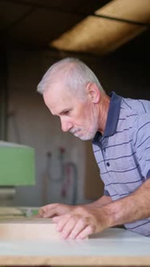 Craftsman Sanding Wood in Workshop at Table