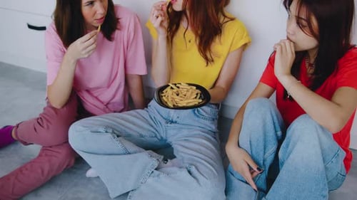 Three Friends Enjoying French Fries in Kitchen