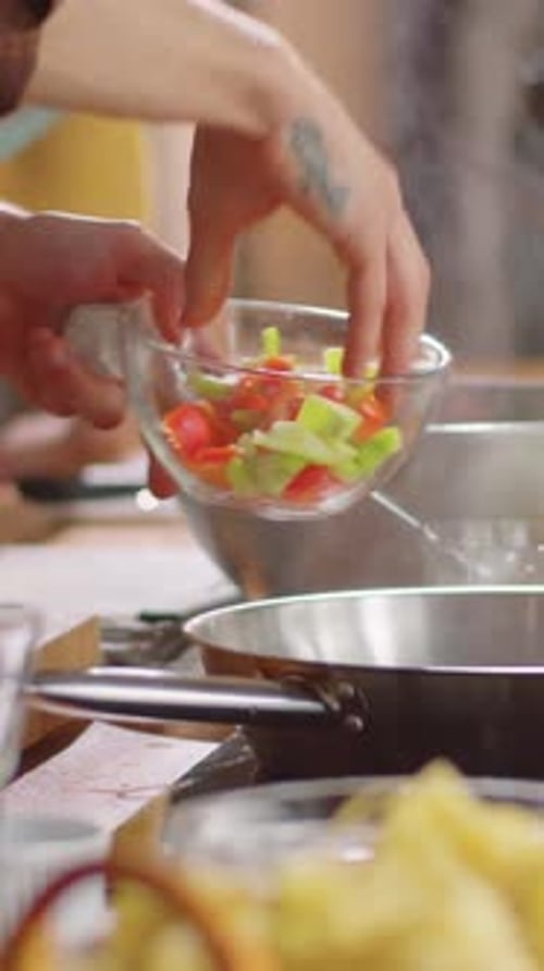 Chef Adding Vegetables to Frying Pan for Cooking