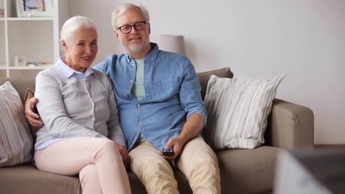 Senior Couple Relaxing on Sofa Watching Television
