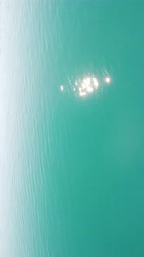 Vertical Aerial View on Sea Water Surface Camera Flies Over Clear Sea Water Sun Glare Abstract