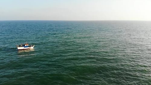 Fishing boat sailling to the horizont at sunset