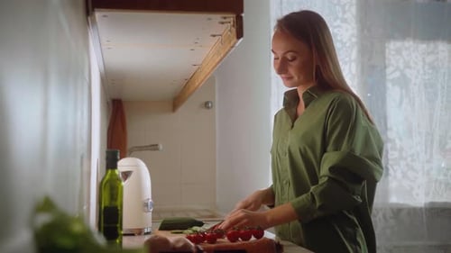 Woman Prepares and Cuts Vegetables in Bright Kitchen