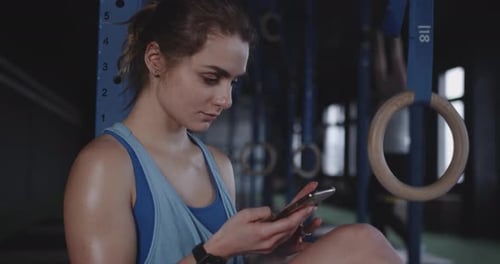 Woman Using Cell Phone at the Gym