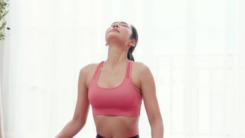 Woman Practicing Yoga and Neck Stretches Indoors