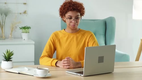African American Girl Using Laptop Computer Having Video Chat at Home Office
