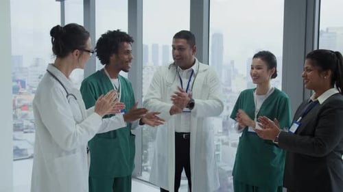 Happy Multiethnic Doctors Clapping Hands in Hospital Hall