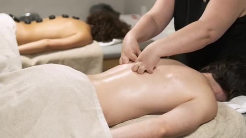 Masseuse Delivering a Relaxing Back Massage in a Tranquil Spa Environment