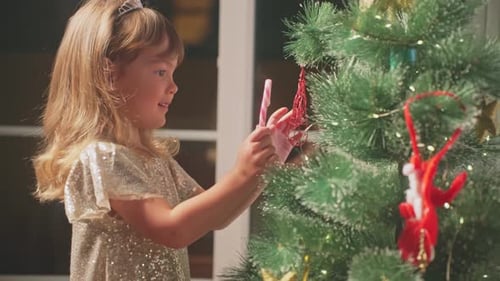 Little Girl Decorating Christmas Tree in Cozy Home