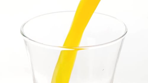 Bright Yellow Juice Pouring into a Glass