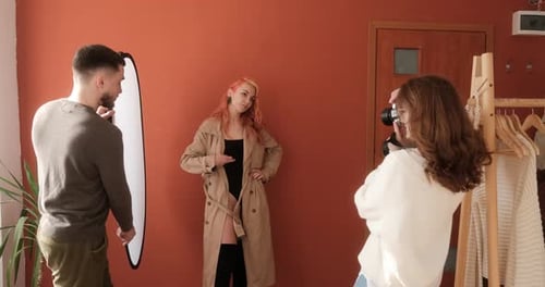 Process of a Photo Session in the Studio Female Photographer with Male Assistant Taking Pictures of